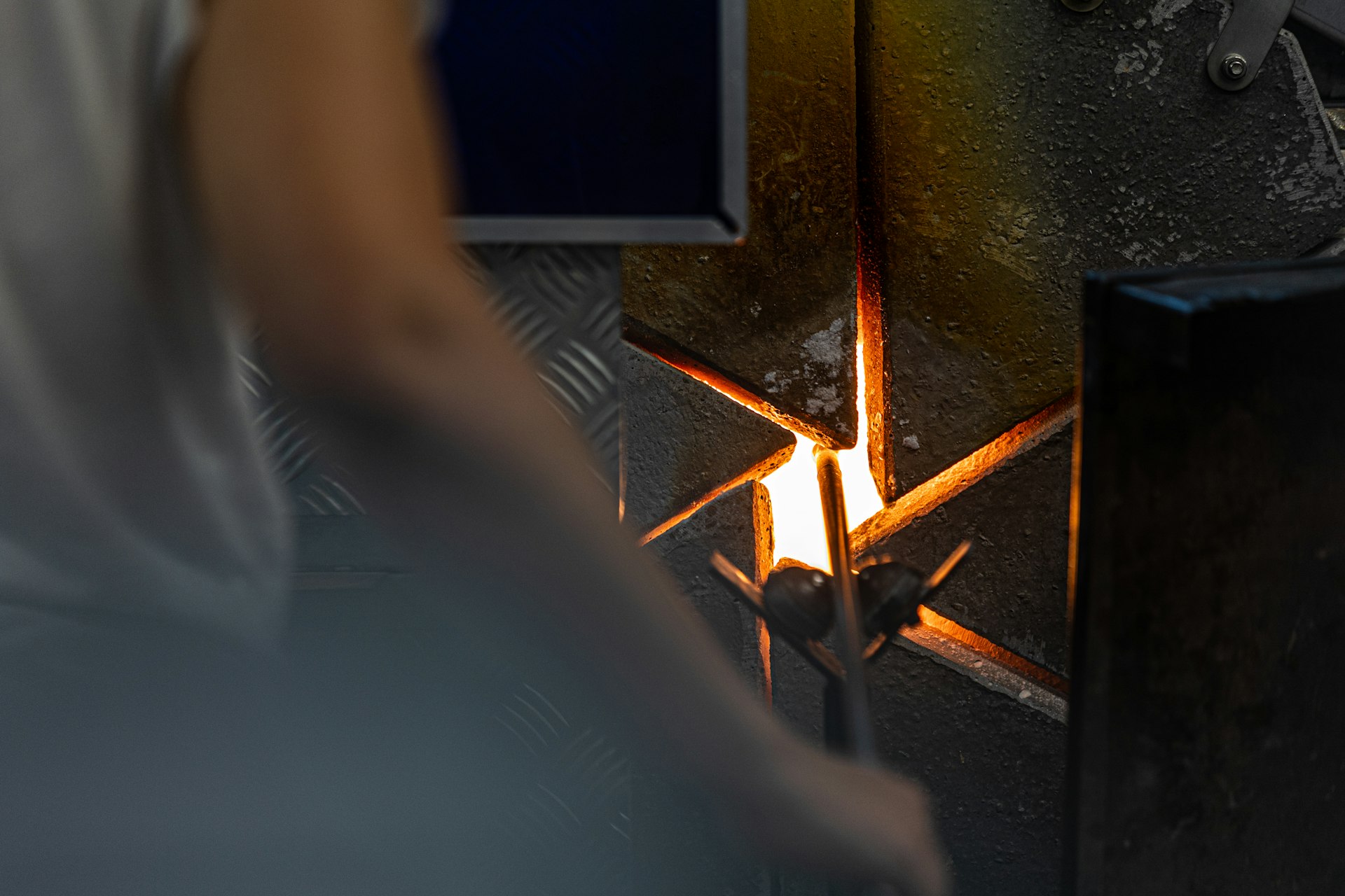 A worker is crafting near a glowing, hot furnace.